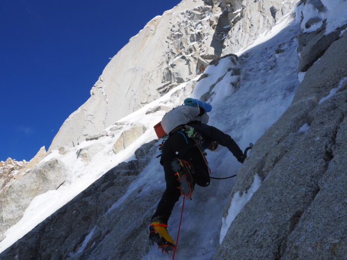 A climber on a difficult section of mixed granite rock and ice.