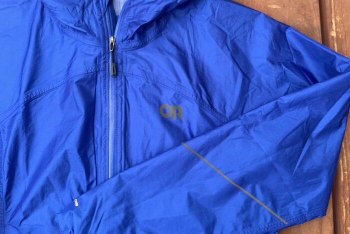 The OR Helium jacket is shown. It's blue, and has a reflective strip on the forearm and the a reflective logo.