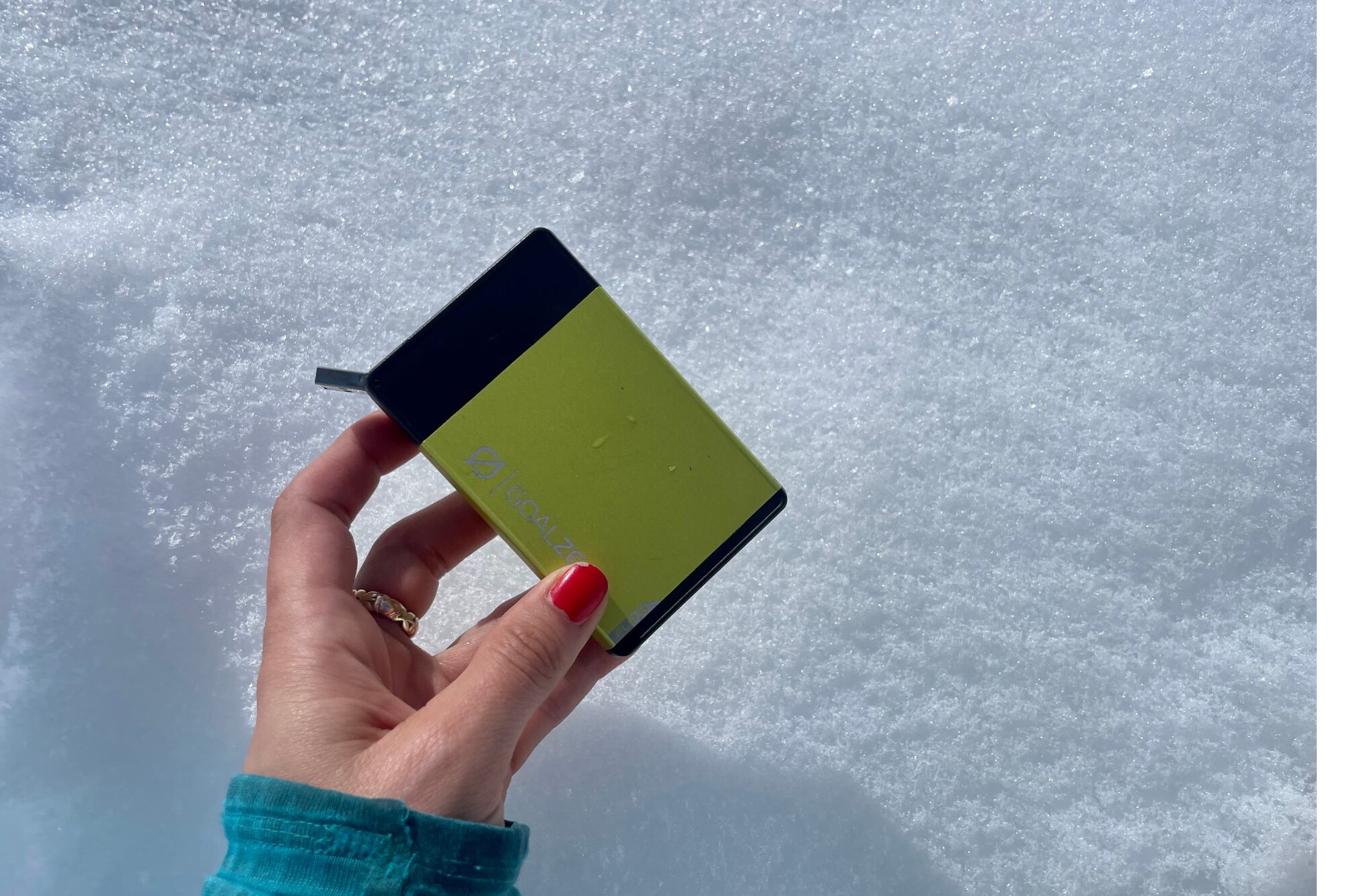 Chelsey holds the Goal Zero 36 over a snowy background.